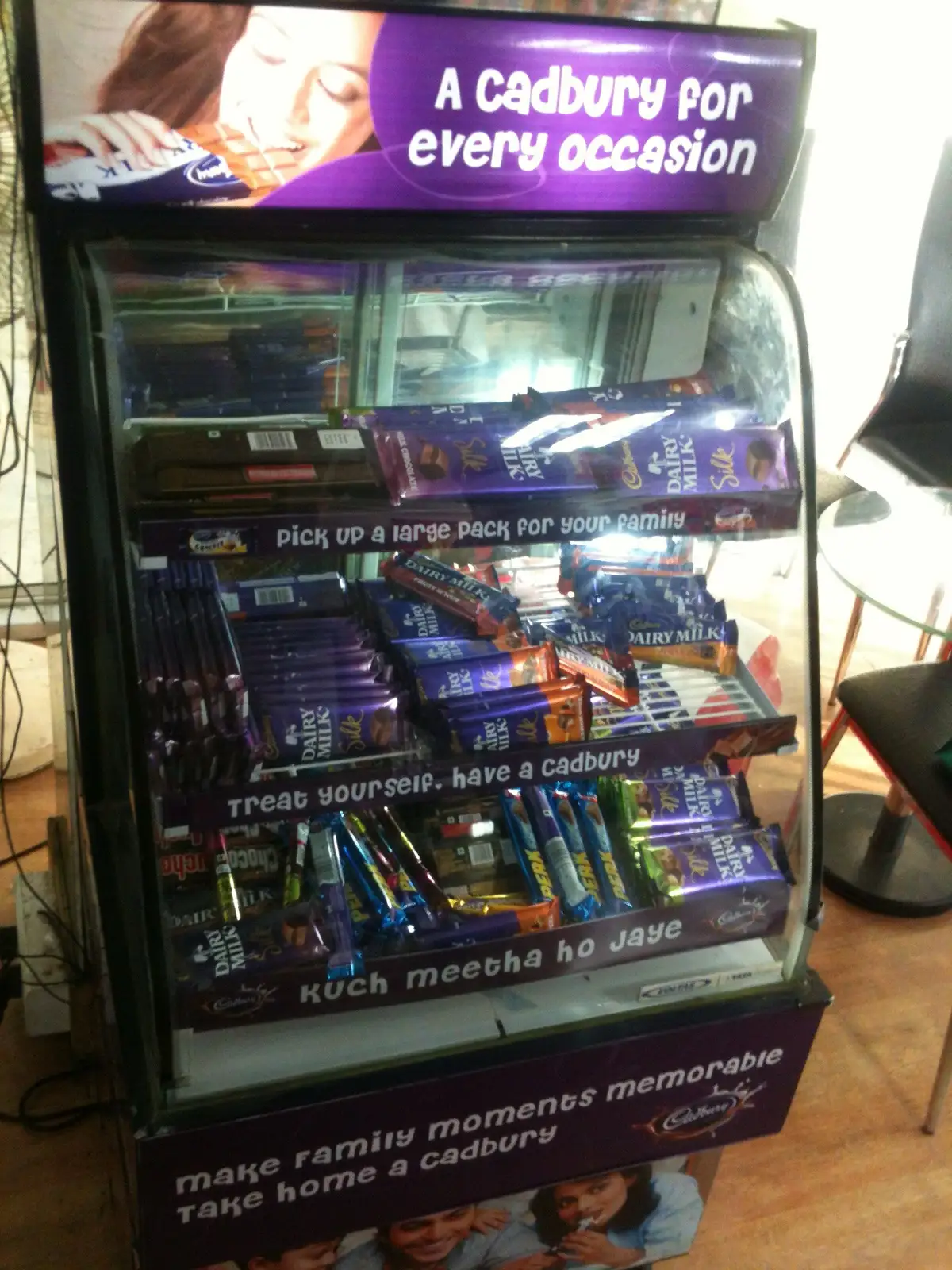 A shop shelf in India stocked with Cadbury chocolate under a sign reading A Cadbury for every occasion