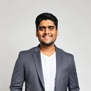 Tanay Choudhary in a grey blazer, smiling